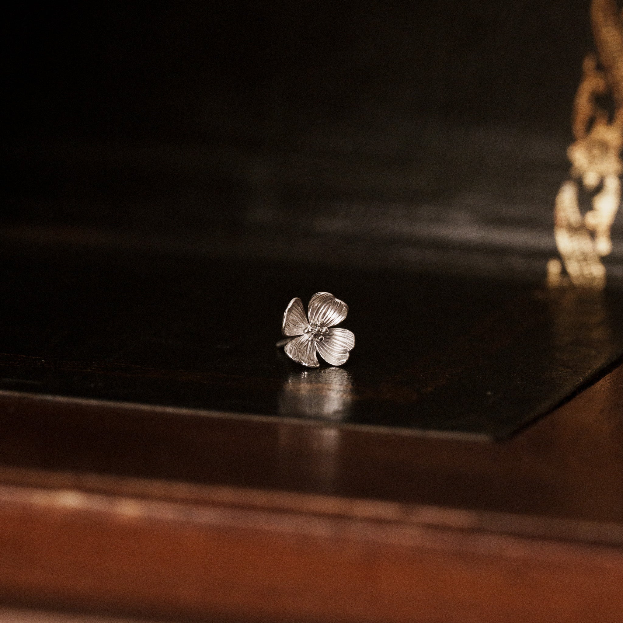Detailed look of a 925 sterling silver dogwood flower shaped earring showing petal layers
