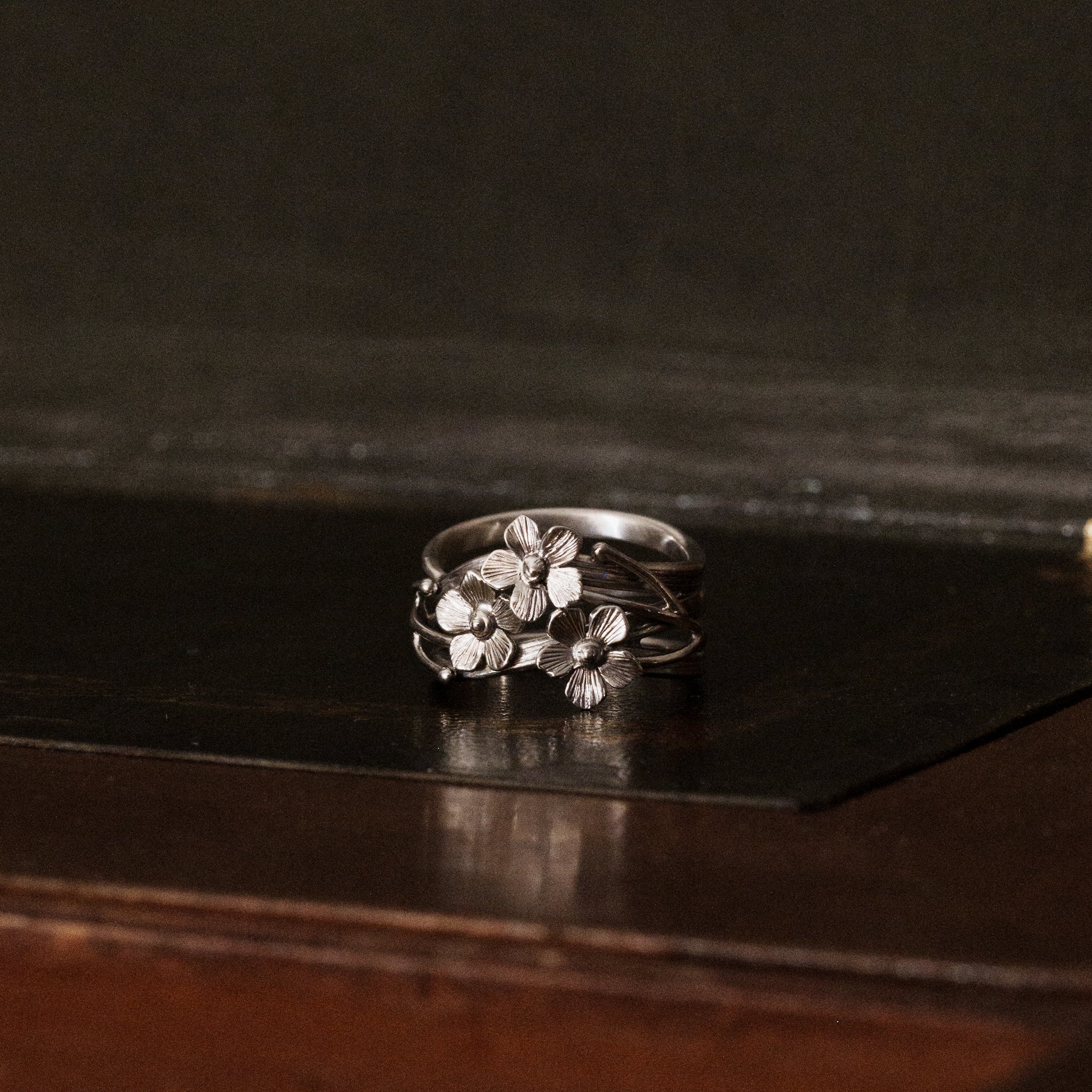 a 925 sterling silver forget-me-not flower shaped ring with three floral petals