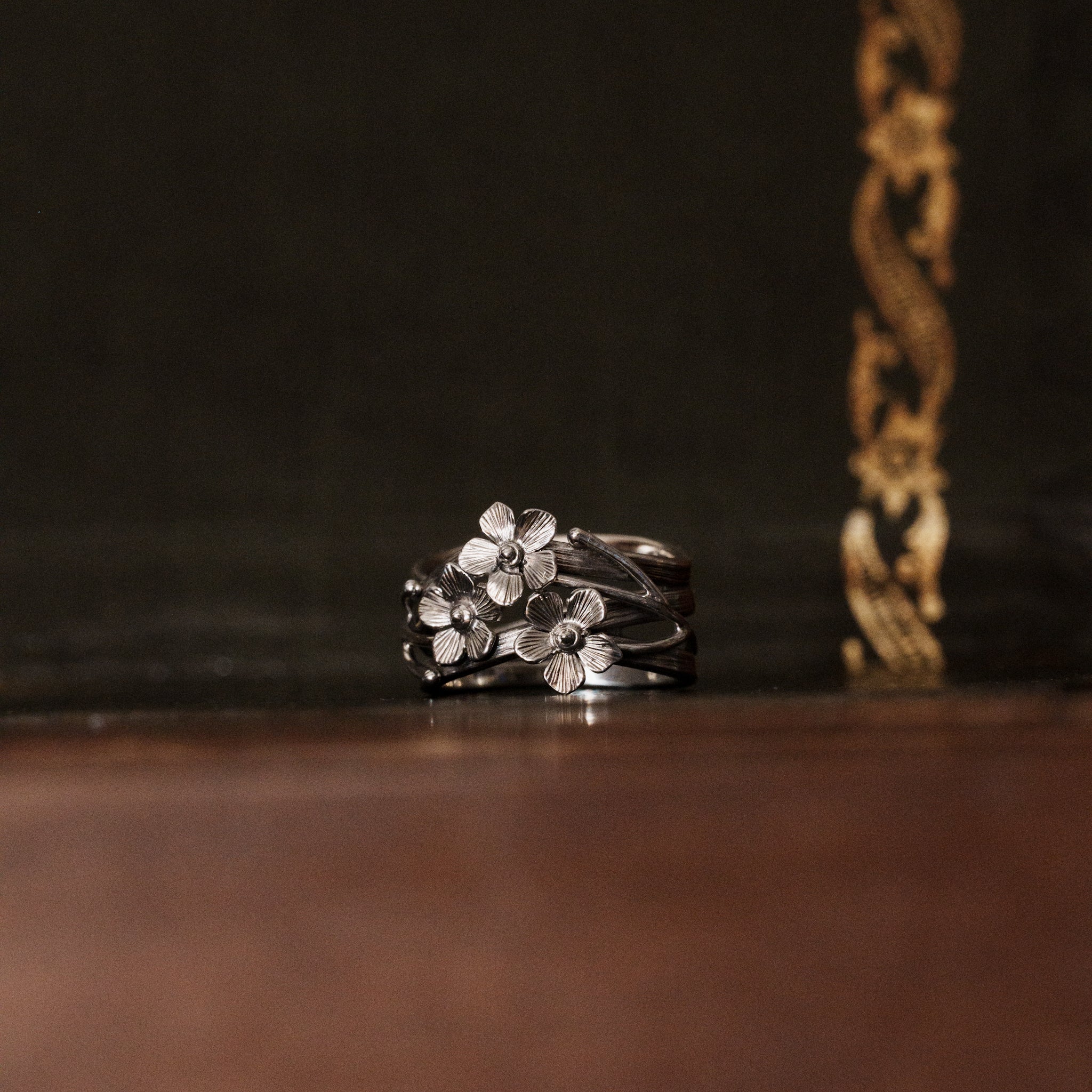 a 925 sterling silver forget-me-not flower shaped ring with three floral petals, vines and branches in a closer look